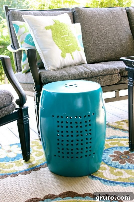 A ceramic garden stool, repurposed and spray-painted, serving as a stylish and functional side table in an outdoor setting.