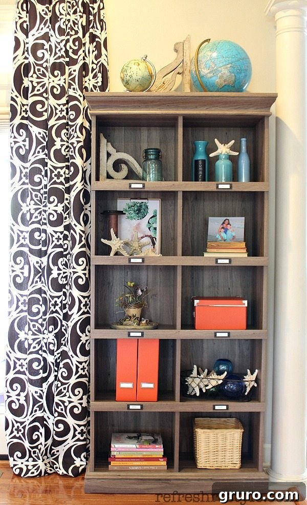Stylish living room storage with decorative boxes, plants, and art on a Sauder Urban Classic Bookcase.