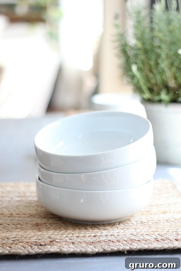 Better Homes and Gardens white bowls are perfect for salads and soups. The white porcelain goes with everything. Love it on this gray farmhouse table! White bowls and natural placemats on a gray farmhouse table