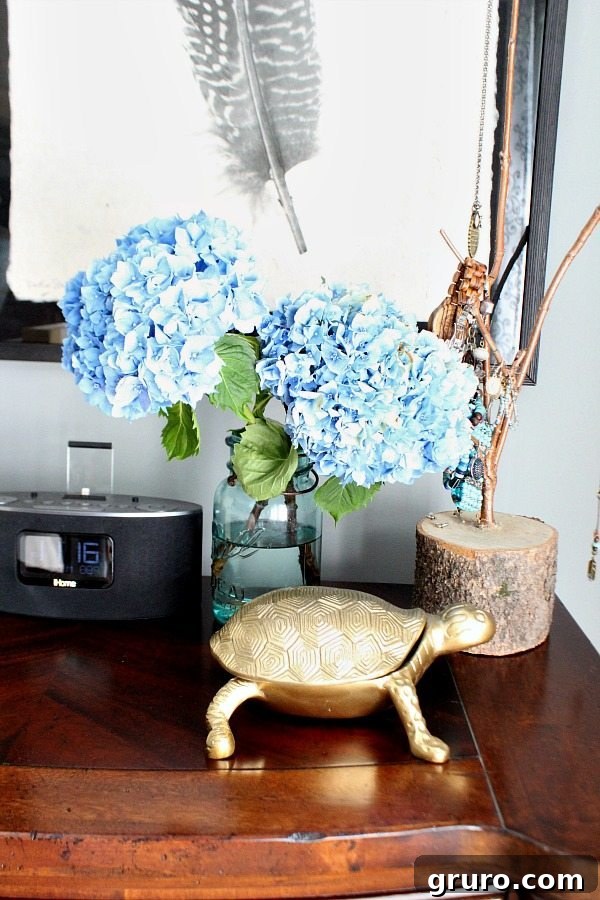 An aqua mason jar on a nightstand, beautifully filled with fresh hydrangeas