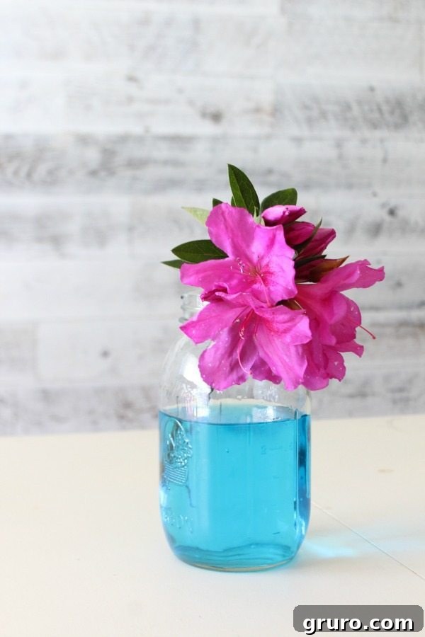 Clear mason jars with blue-tinted water, creating a pretty and vibrant vase