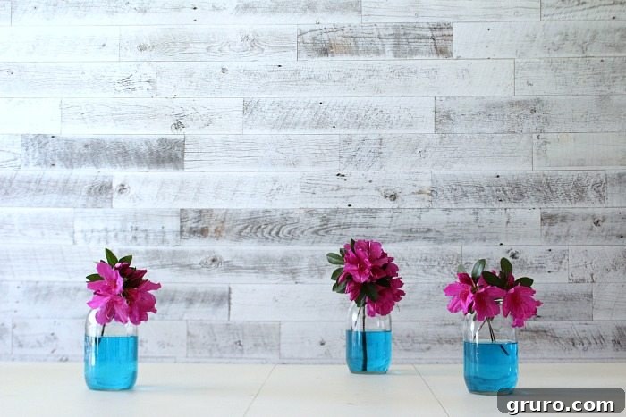 Azaleas in mason jars with vibrant blue water, perfect for an elegant dining table setting
