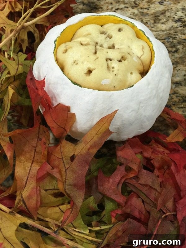 Instant Thrift Store Pumpkin Glow-Up 4 Partially painted pumpkin with first layers of fall leaves being inserted into floral foam