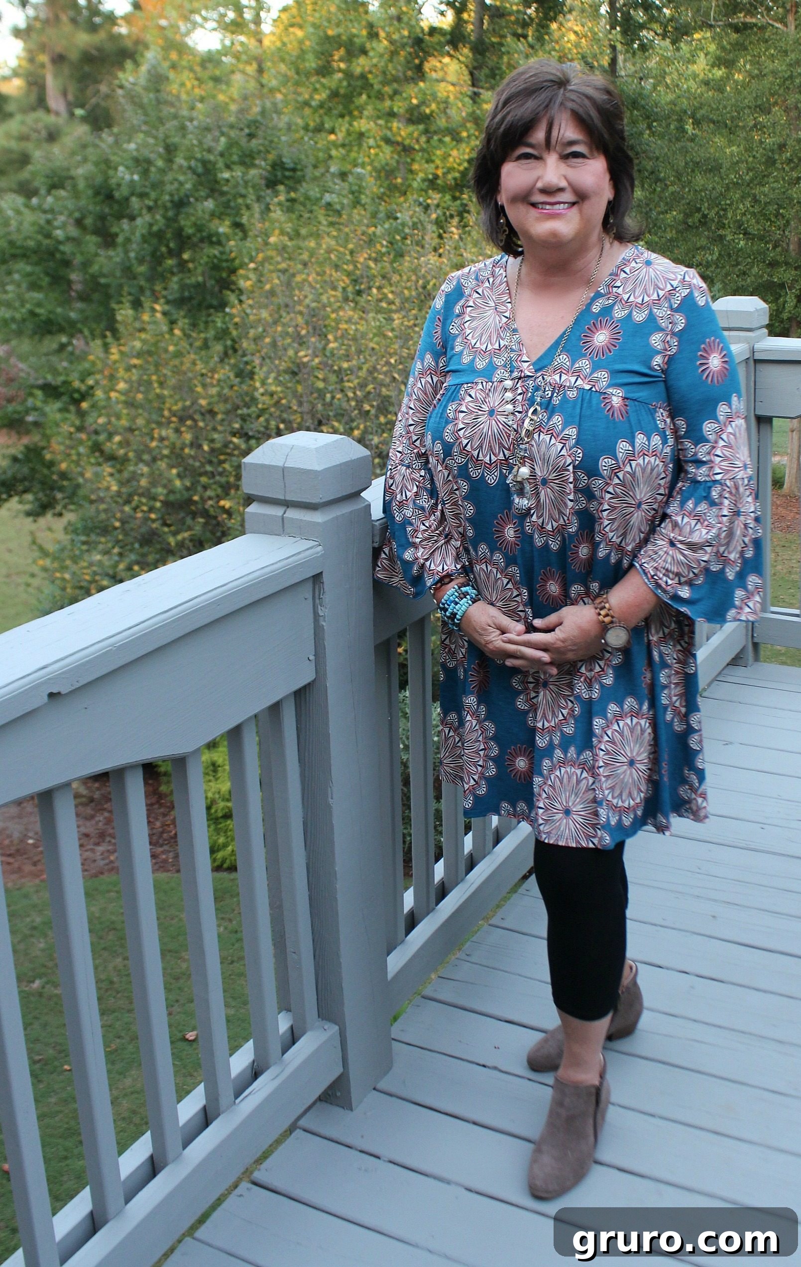 The Bryce Tunic in a teal floral pattern, modeled by the author in an outdoor setting, demonstrating its flow and comfort.