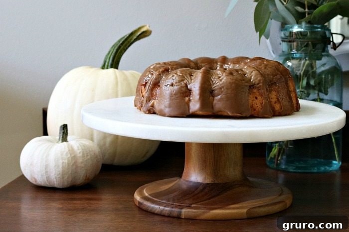 Farmhouse Autumn Gathering Table 14 Spice cake elegantly served on a marble and wood cake stand, showcasing beautiful dessert presentation