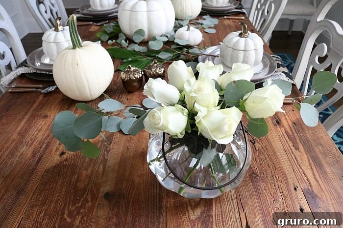 Farmhouse Autumn Gathering Table 9 Neutral farmhouse table setting featuring white pumpkins and white roses, creating an elegant fall display