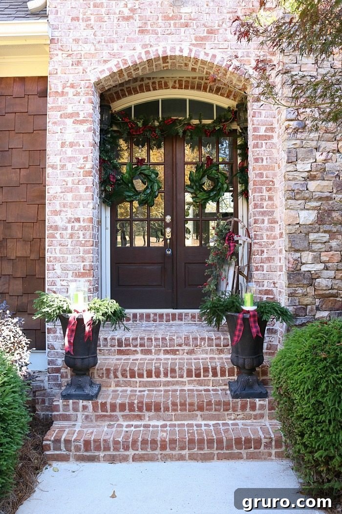 Rustic Christmas Porch - Magnolia Wreaths Hung with Plaid Ribbon and Urns Filled with Greenery plaid-and-magnolias-make-a-beautiful-christmas-porch-idea