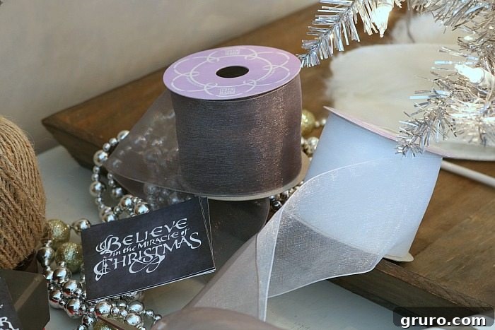 Soft gray and white ribbons create elegant bows, adding a touch of sophistication to Christmas presents.