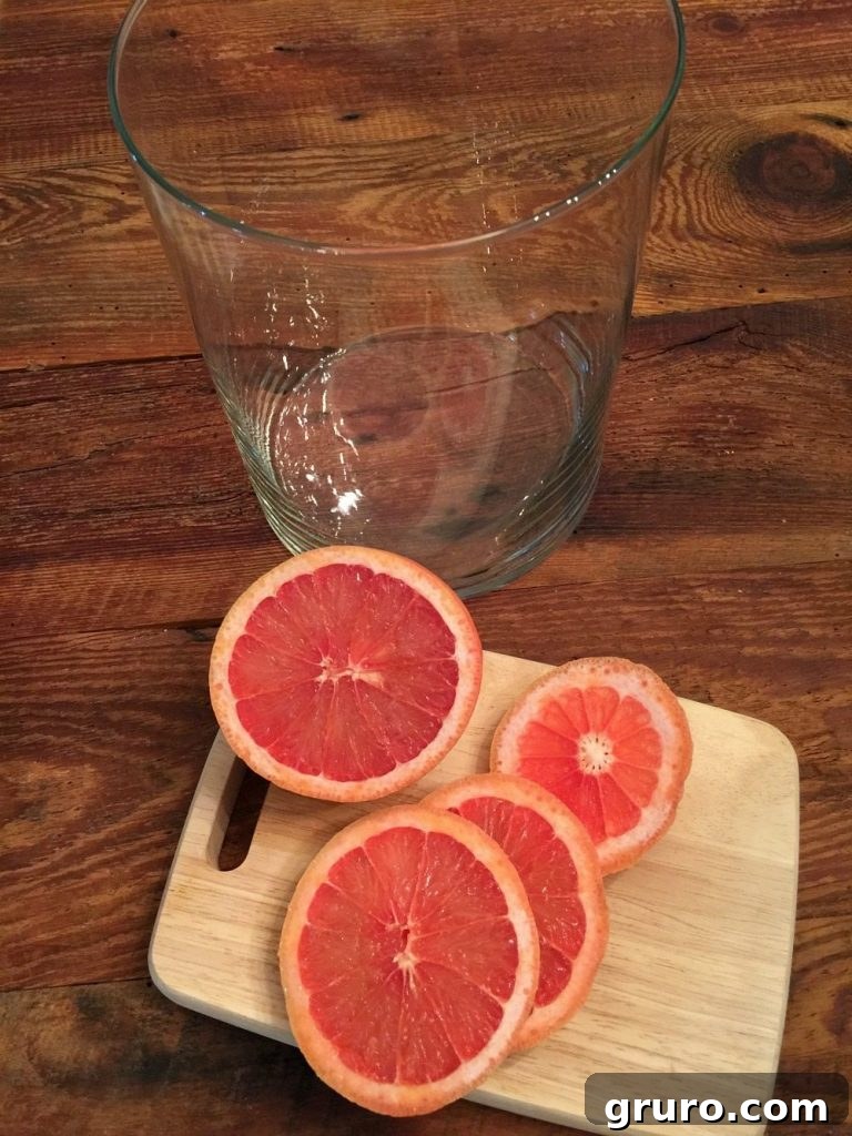 Red grapefruit slices arranged in a vase for a floral display
