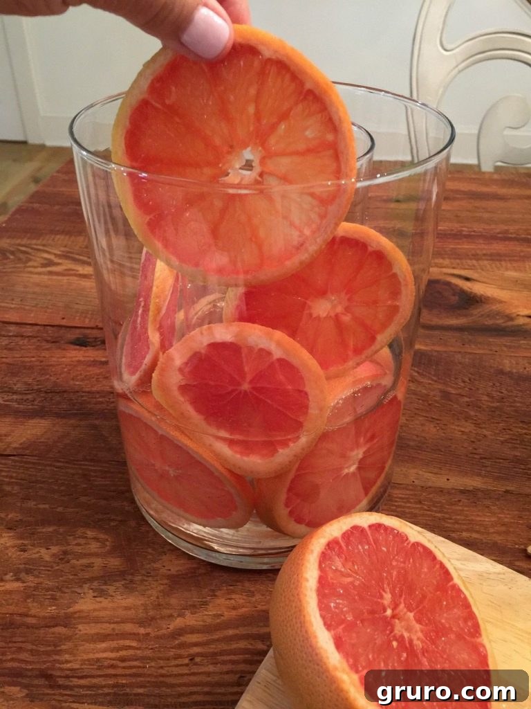 Placing grapefruit slices between two layers of glass vases