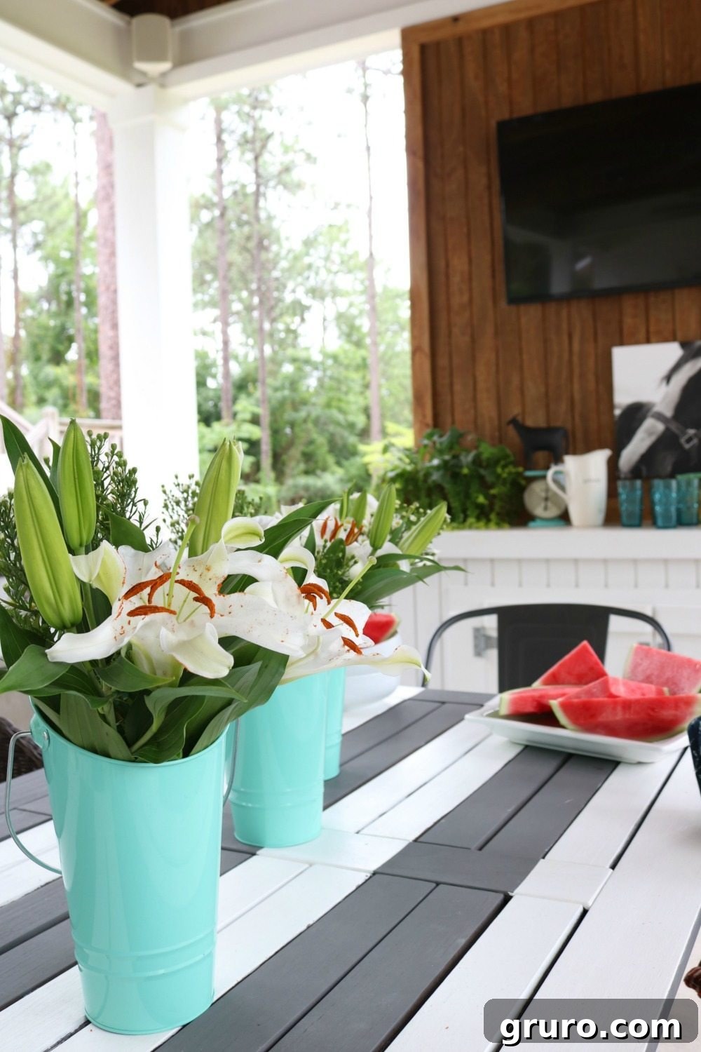 Eclectic outdoor dining chairs and a DIY farmhouse bench arranged around a striped table on a summer porch