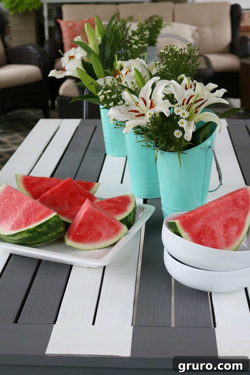 Close-up of a gray and white striped dining table with summer decor on a farmhouse porch