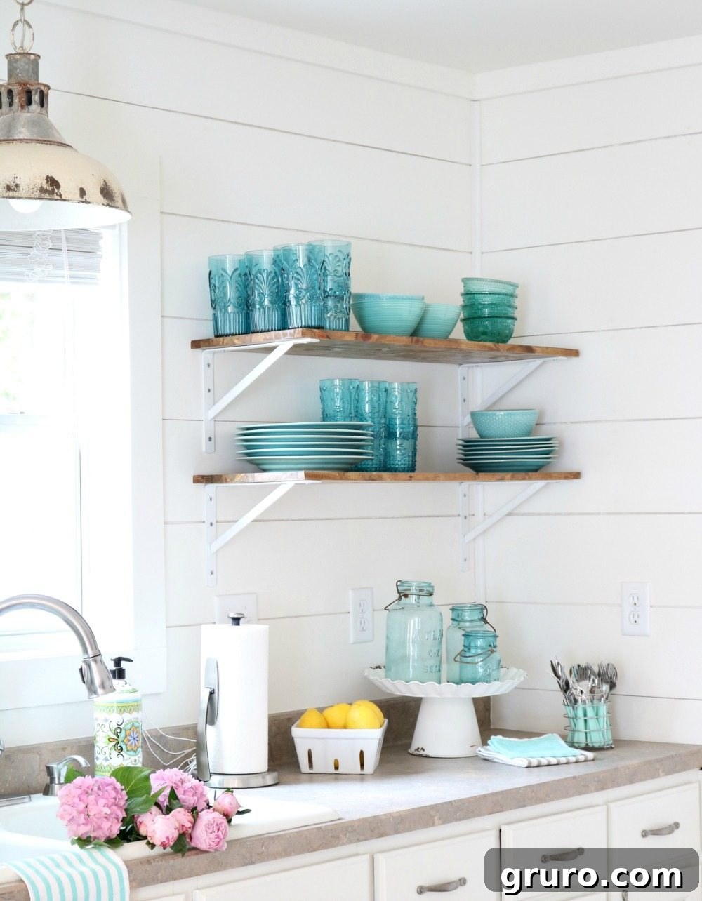 Alabaster white walls paired with shiplap and open shelves, beautifully displaying aqua and turquoise dishes, perfect for a cheerful farmhouse cottage kitchen.