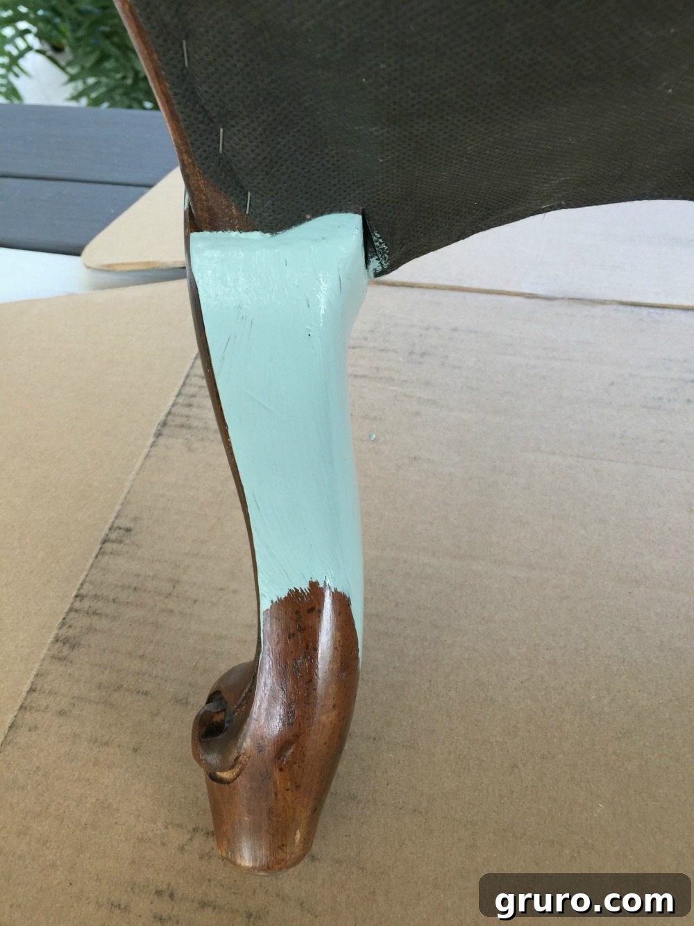 Process photo of painting a fabric ottoman with chalk paint, showing transformation in progress