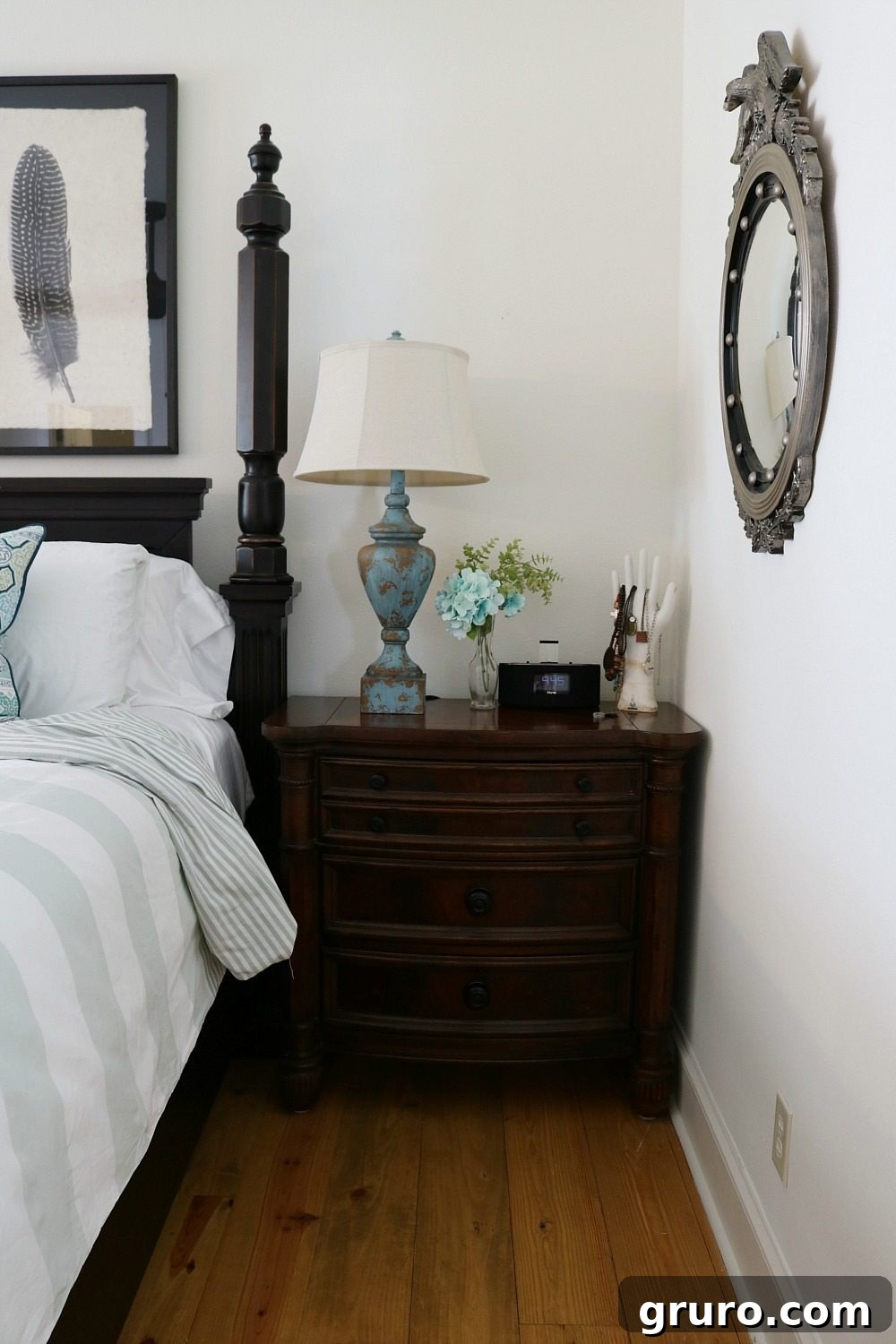 White bedroom with dark furniture and striped blue and white bedding