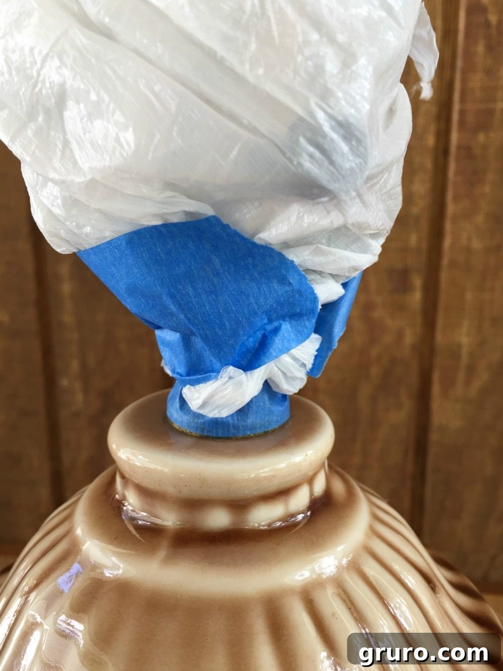 Use tape and a plastic bag to protect areas you don't want to paint on the lamp