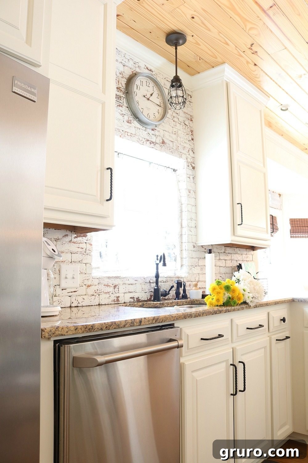 Galvanized clock on the brick wall in the kitchen at Refresh Restyle adding rustic charm