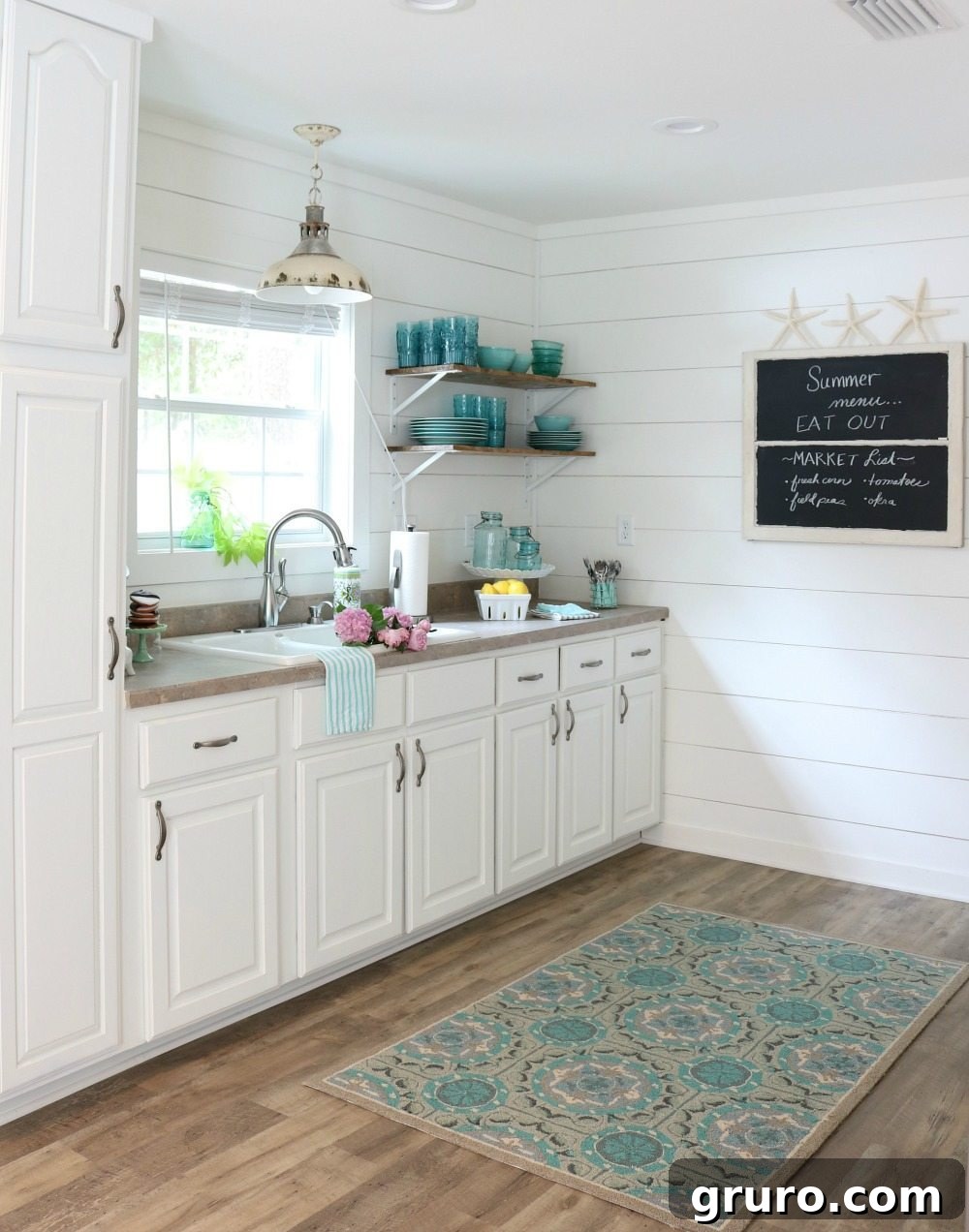 Fully painted cabinets and shiplap with open shelving creating a bright farmhouse cottage kitchen.