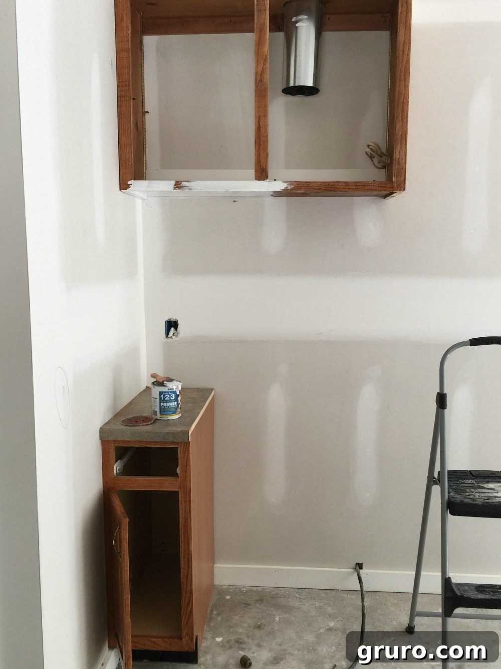Cottage kitchen stove area before cabinet painting, showing the original dark cabinets.