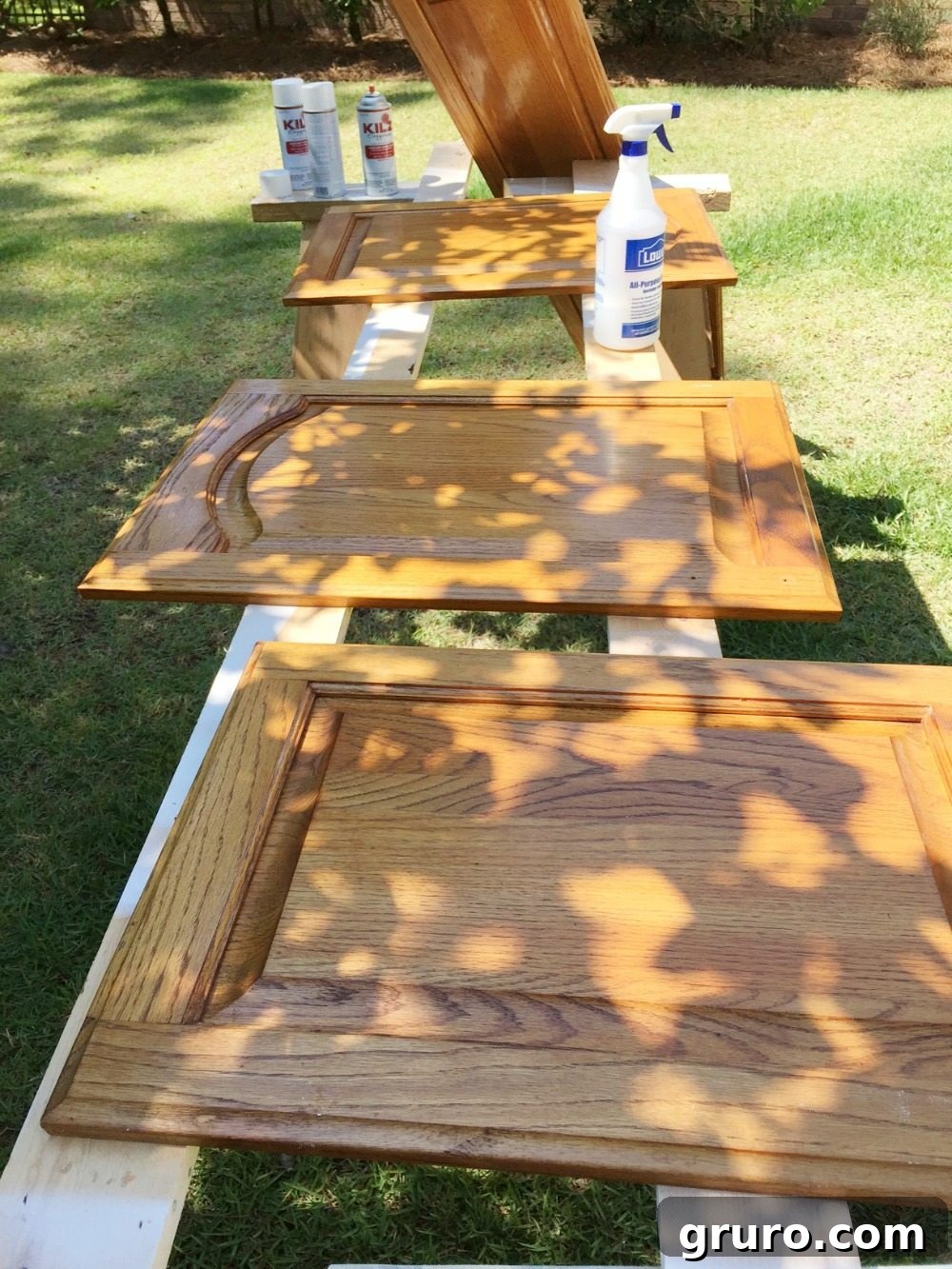 Cleaned cabinet doors being primed before the first coat of paint.