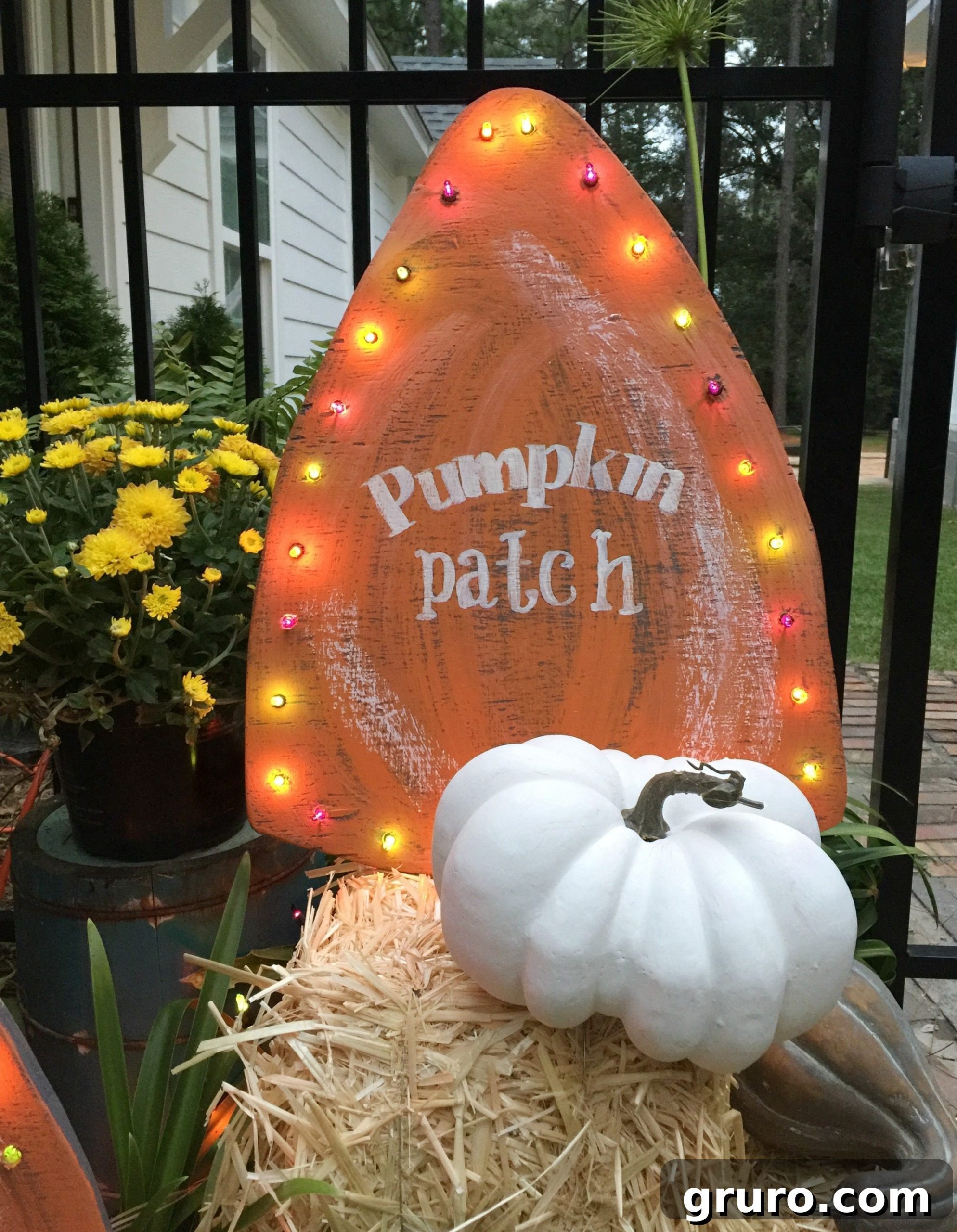 A close-up of a personalized fall harvest yard sign featuring a pumpkin patch stencil