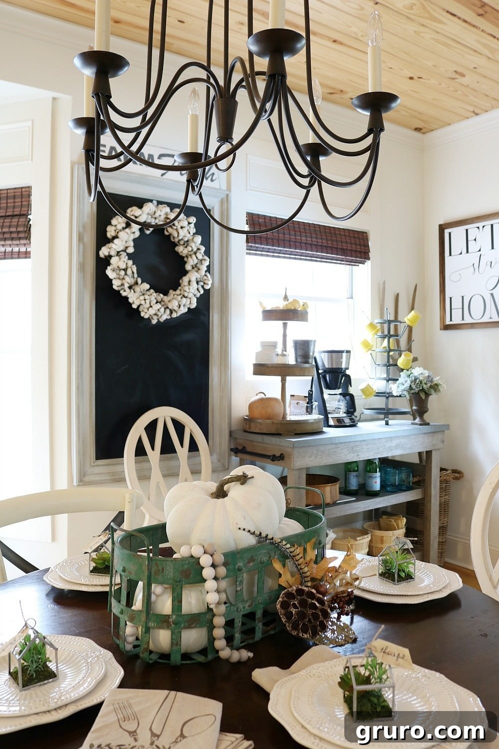 A green metal basket filled with delicate white fall pumpkins, adding a rustic touch to the kitchen.