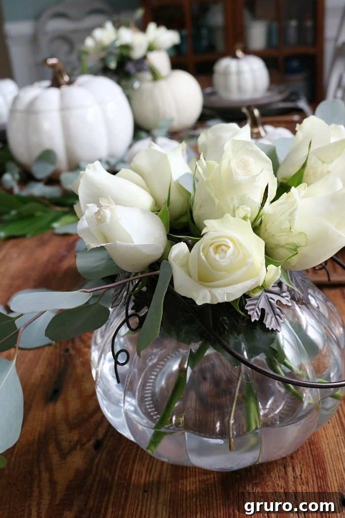 white roses in pumpkin candle holder perfect for a low-profile arrangement