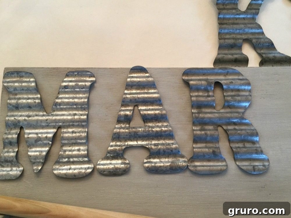 Upcycled Quilt Rack Wall Paper Dispenser 11 Close-up of galvanized letters spelling MARKET on the repurposed paper roll holder