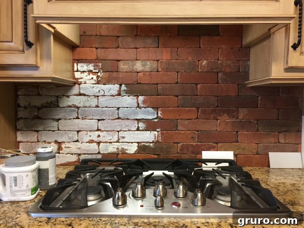 Applying paint to the primed brick backsplash