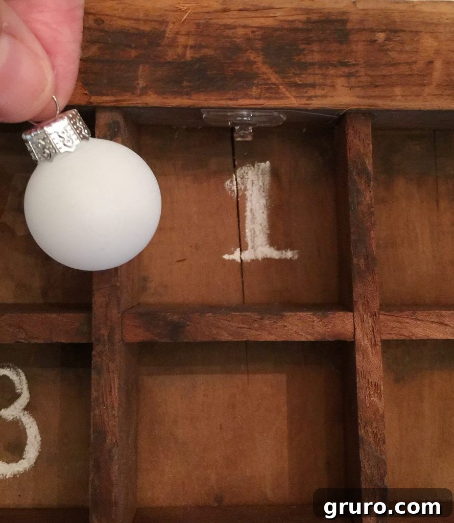 Hanging tiny ornaments for the Advent calendar, creating a charming and festive display.