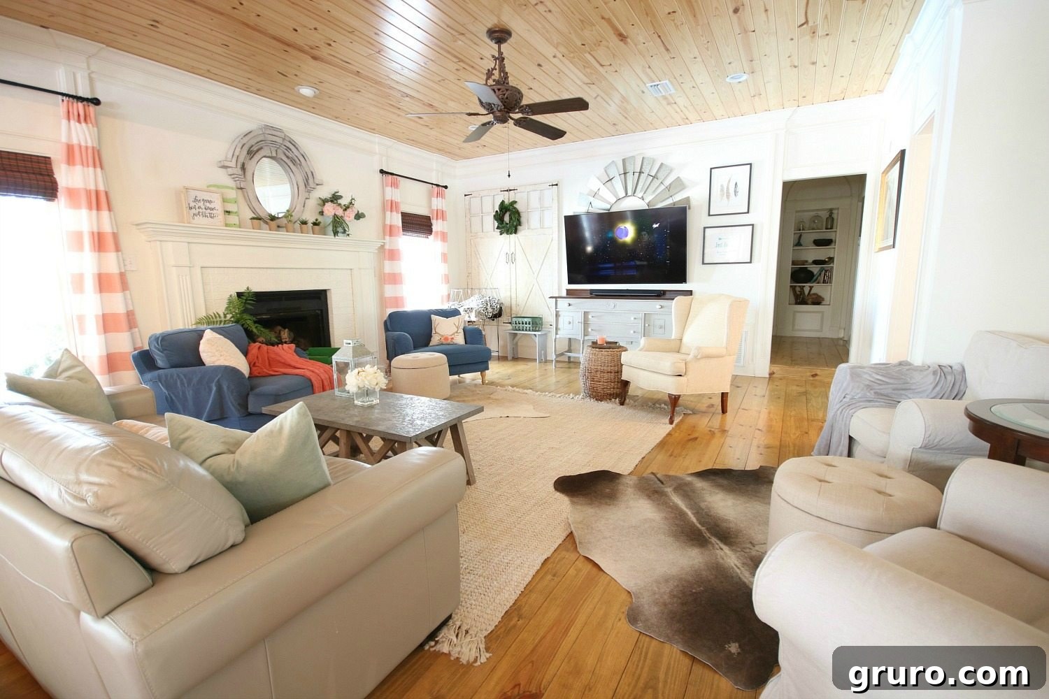 An eclectic farmhouse living room featuring a well-curated gallery wall with a television, a freshly painted fireplace, and abundant colorful accents that bring the space to life. Sponsored by Better Homes & Gardens at Walmart.