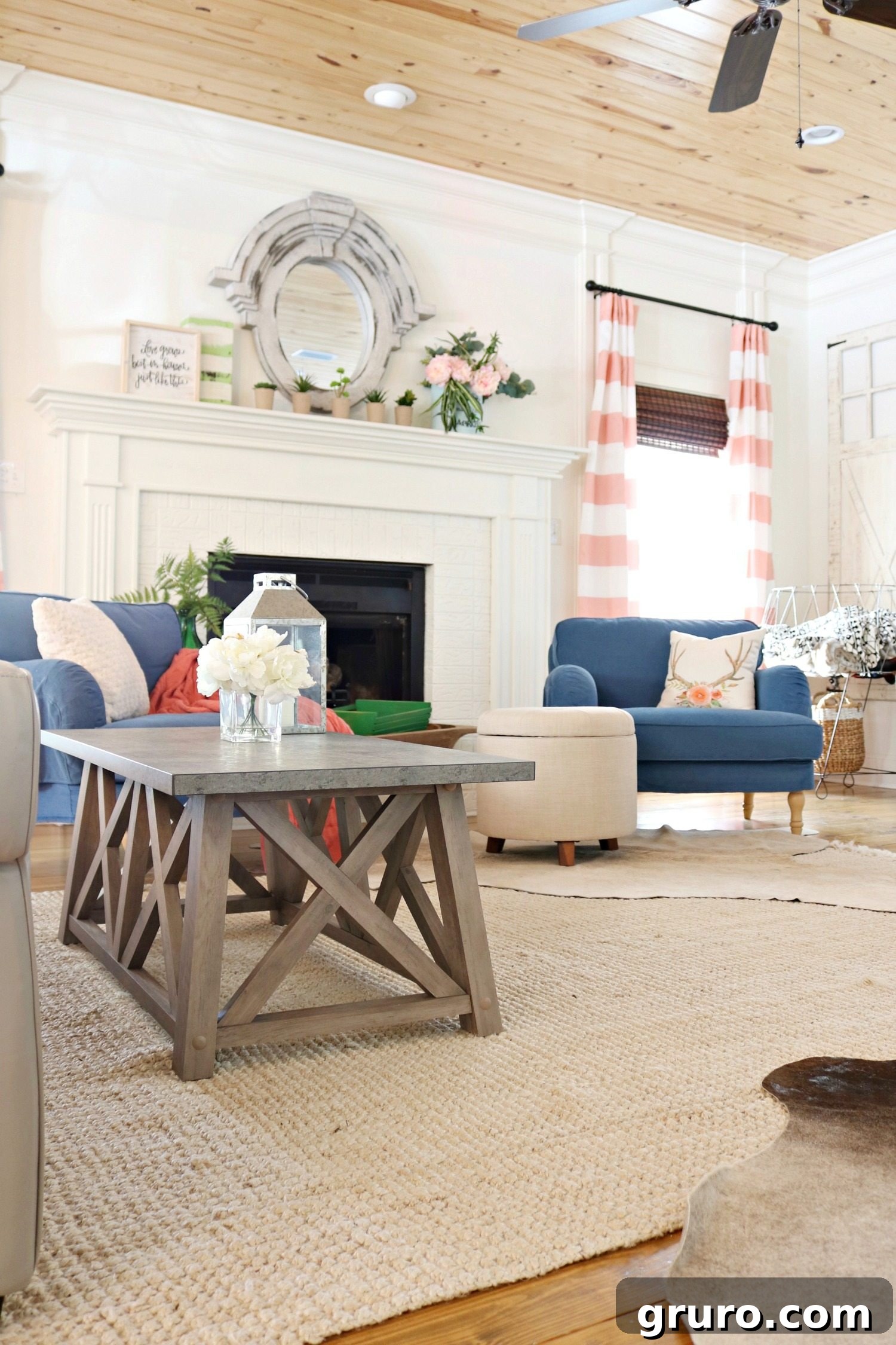 An eclectic farmhouse living room showcasing a stylish coffee table, a gallery wall with a television, a painted fireplace, and vibrant splashes of color. Sponsored by Better Homes & Gardens at Walmart.