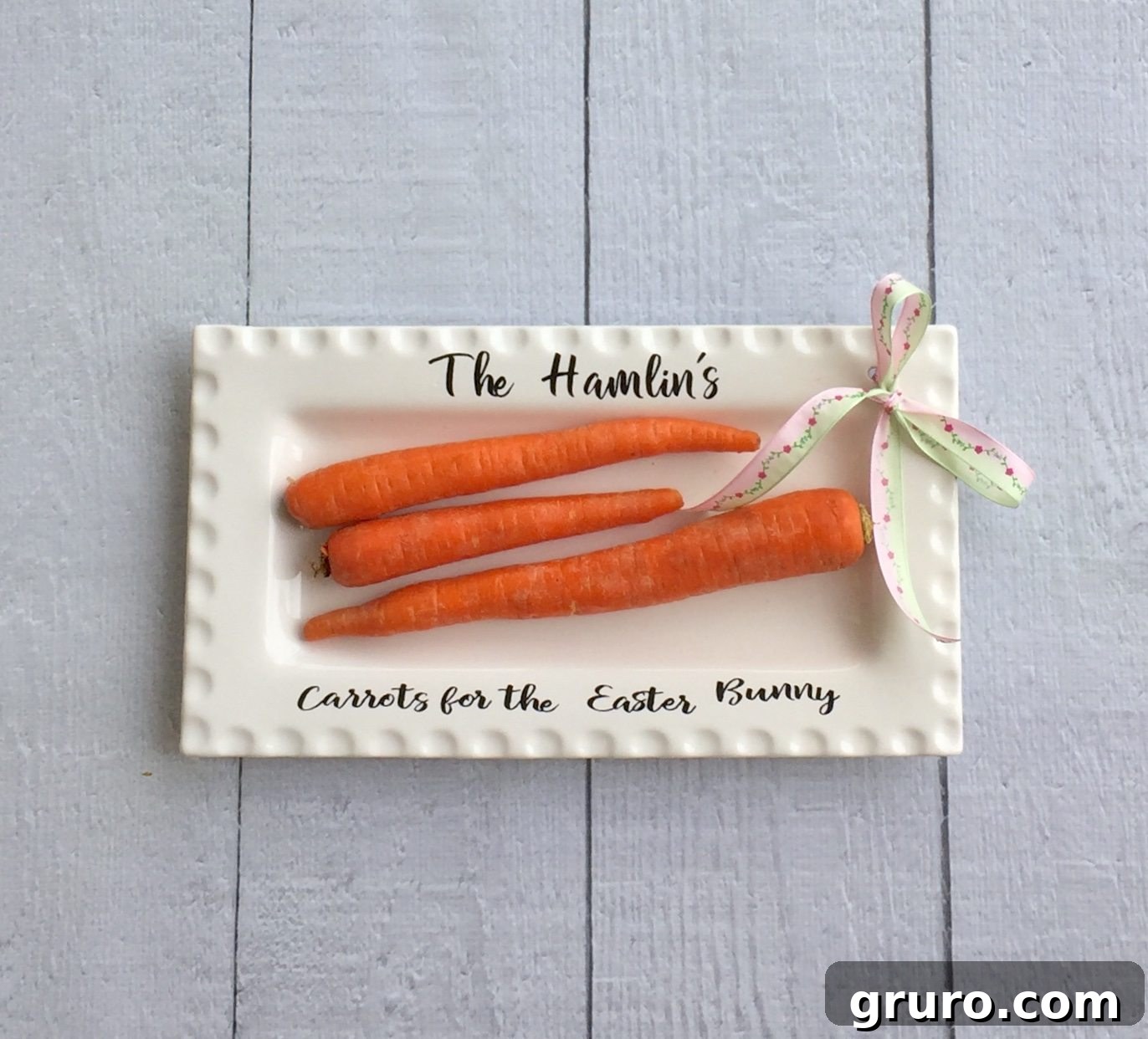 Close-up of a completed ribbon platter with a vinyl design and a carrot, showcasing the decorative ribbon tied on the side.