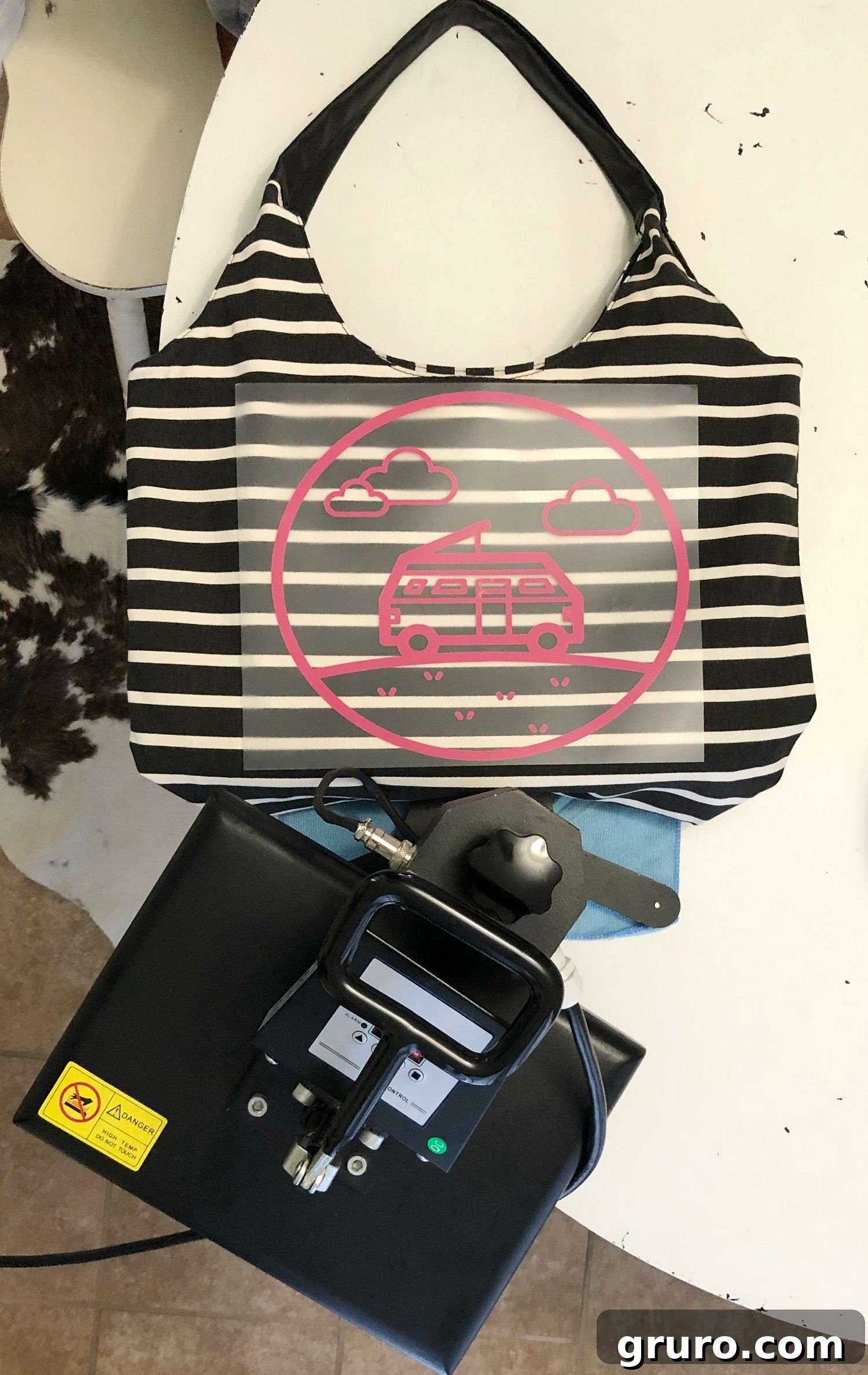 A heat press in action, applying a Cricut vinyl design to an overnight bag