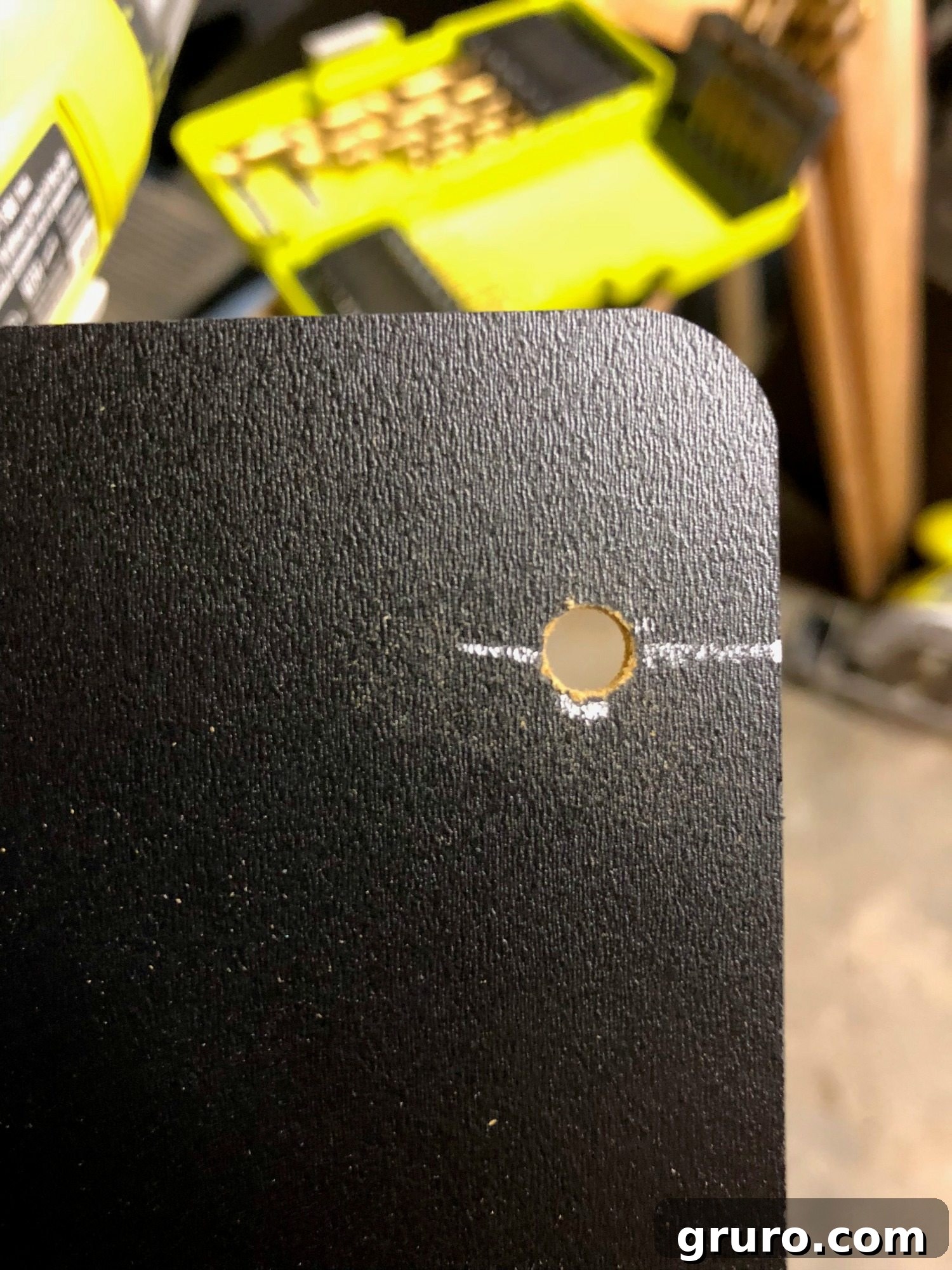 Marking drill spots on the back of a plastic storage bin