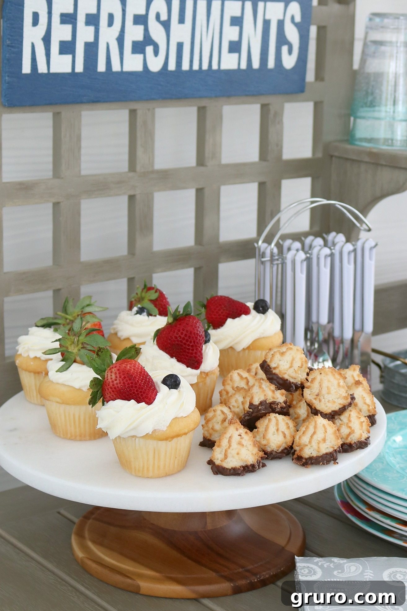 The potting bench creatively used as an elegant dessert table adorned with treats, flowers, and serving dishes.