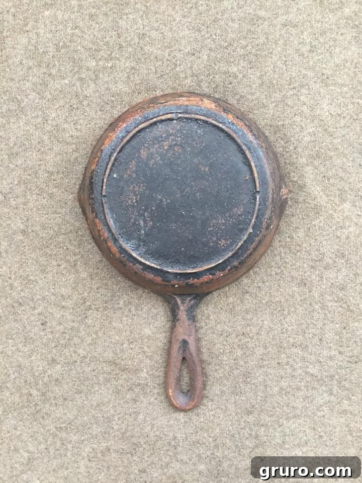The back of a severely rusted cast iron pan before the restoration process began.