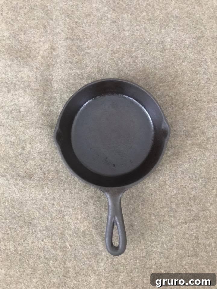 Beautifully restored cast iron skillet after rust removal, cleaning, and multiple seasoning layers, showcasing a perfect non-stick surface.