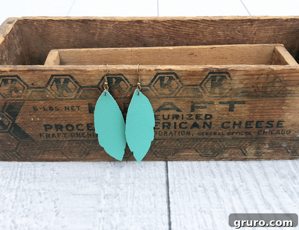 Turquoise Delight: How to Make Leather Feather Earrings – A Quick and Easy DIY Guide Close-up of vibrant turquoise leather earrings made using a Cricut machine, highlighting an easy DIY process.