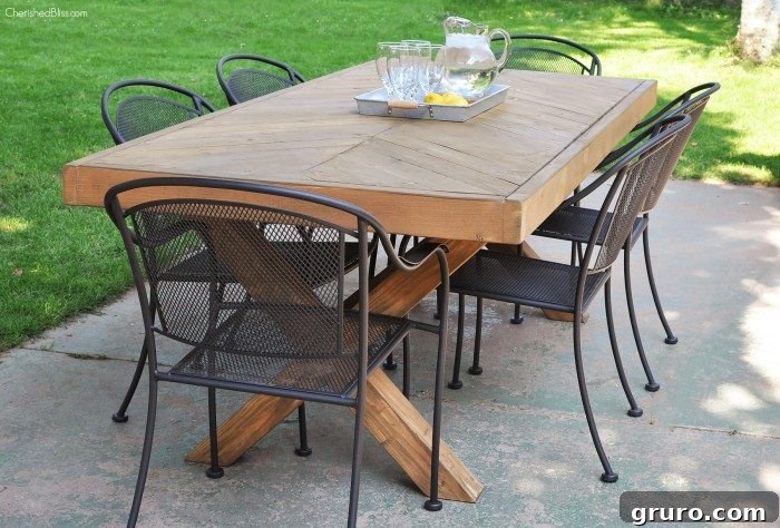 A beautifully crafted wooden DIY outdoor table set for dining, surrounded by chairs on a patio.