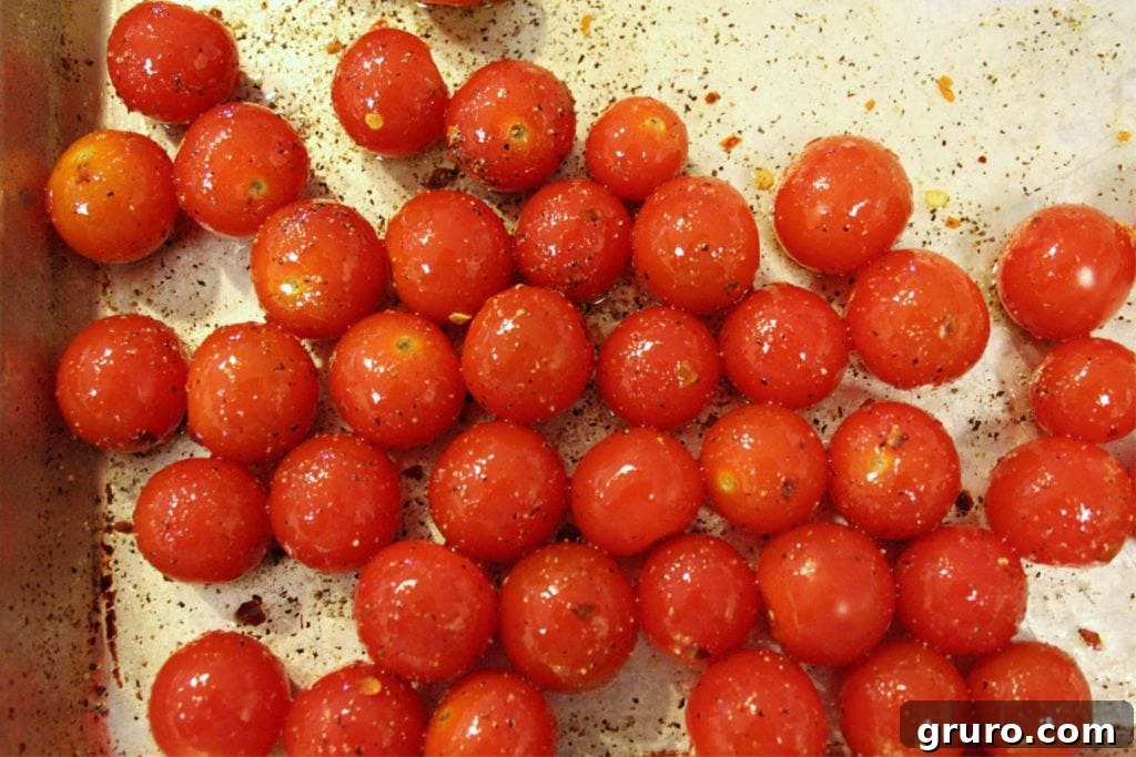 Cherry tomatoes being tossed with olive oil and spices for focaccia topping