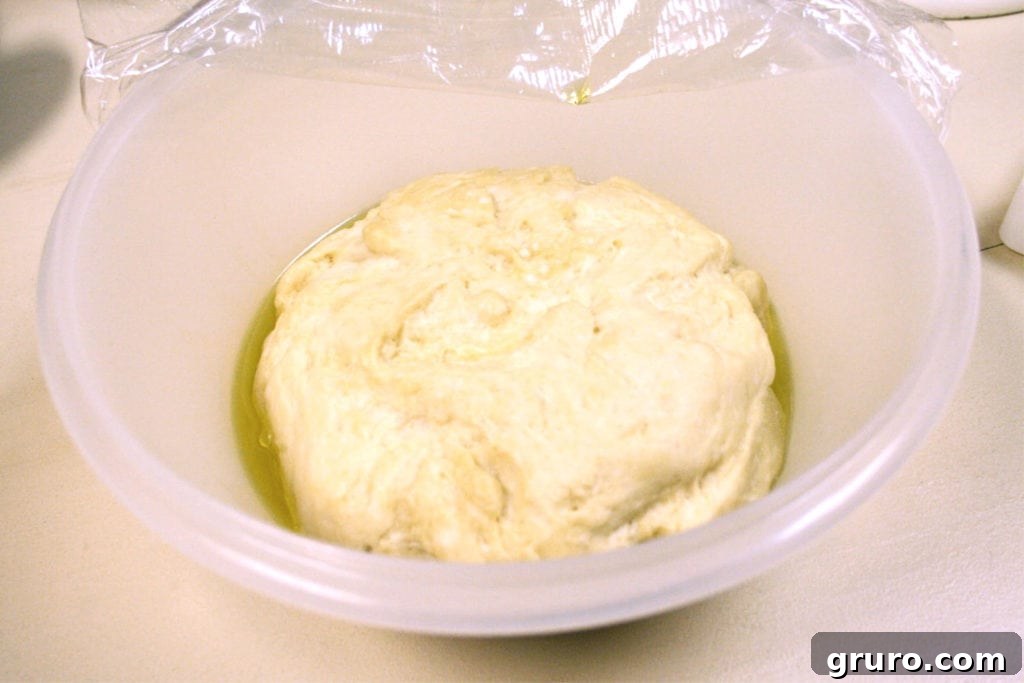 Focaccia dough rising in a bowl, ready for shaping