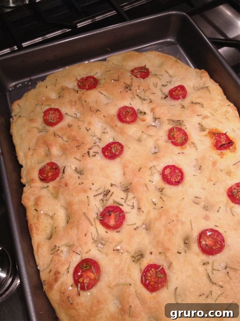 Freshly baked focaccia bread cooling on a rack, showcasing golden crust