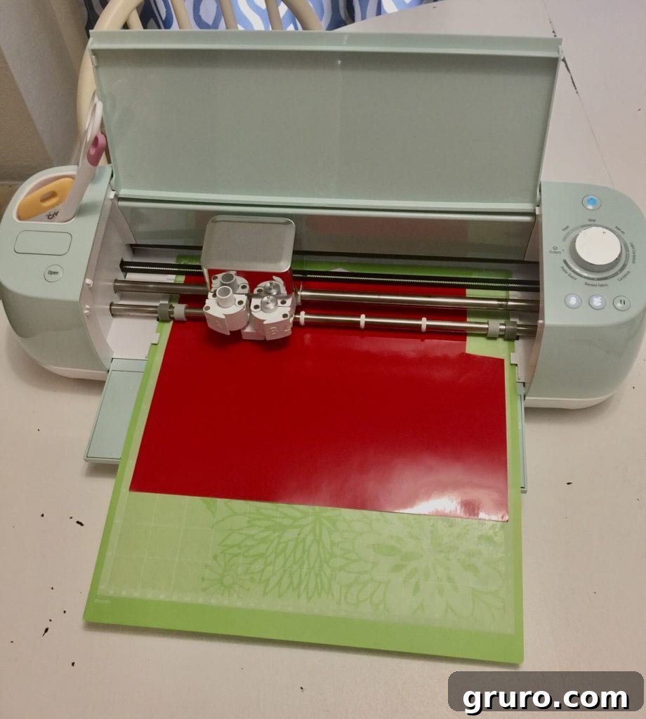 Close-up of a Cricut machine cutting vinyl for a Christmas project.