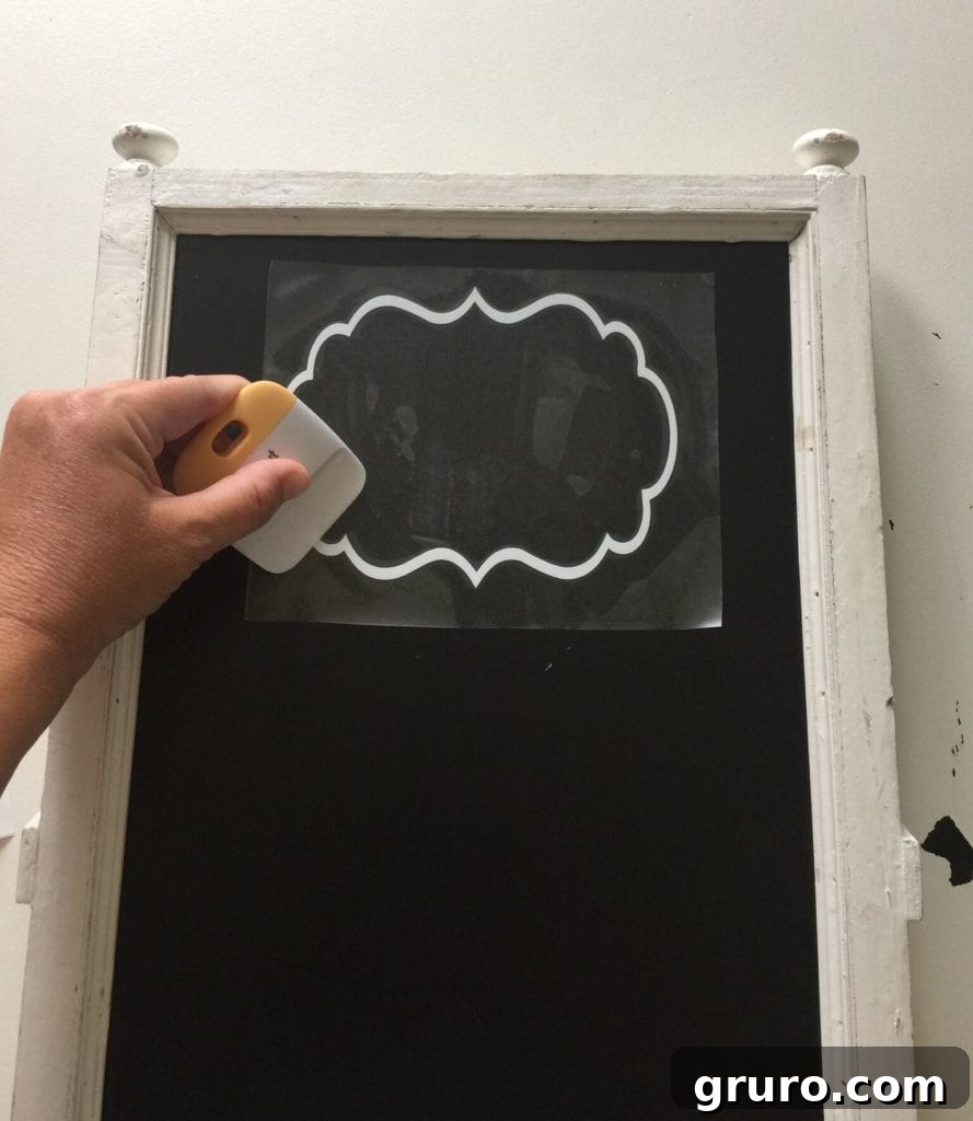 Applying vinyl design to a chalkboard for a Christmas sign.