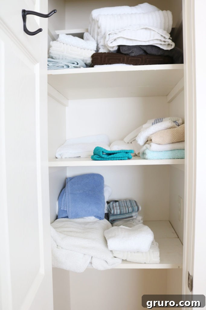 Before linen closet organization - cluttered and messy towel storage