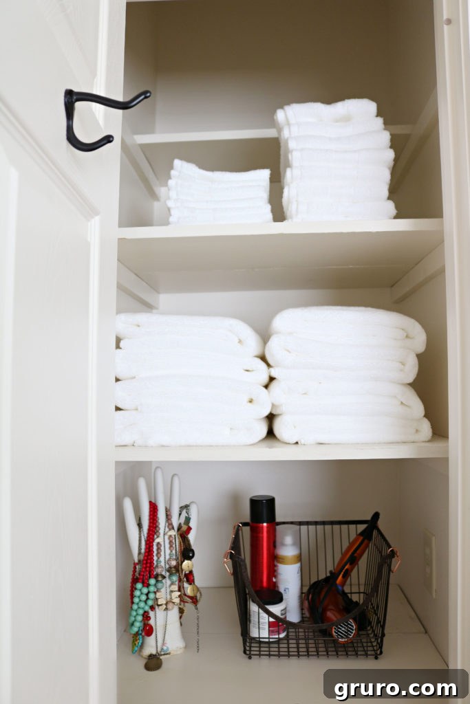 BHG towel closet update - fresh white towels neatly folded with a wire basket for storage.