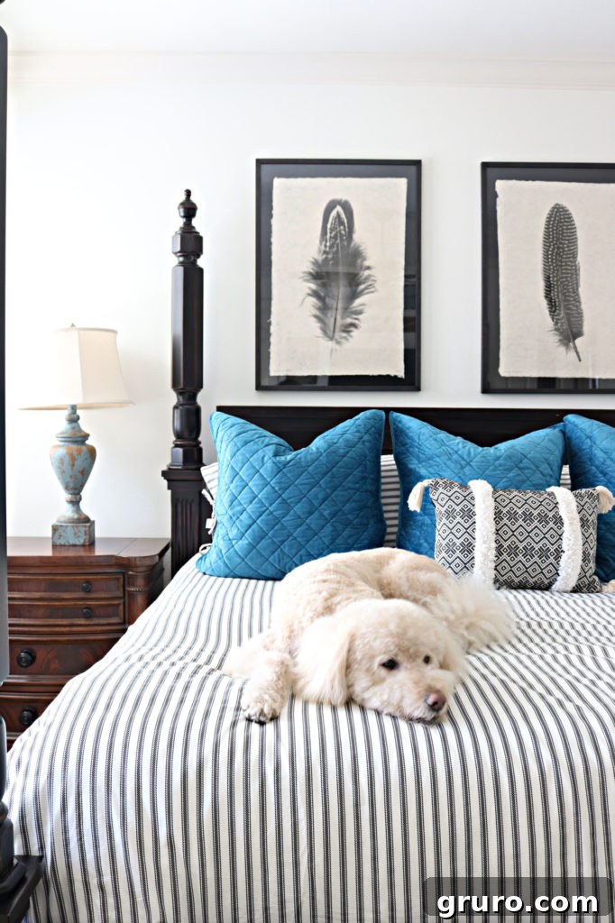 Murphy the dog on the new bedding - quick bedroom refresh with ticking stripe duvet and blue Euro shams.