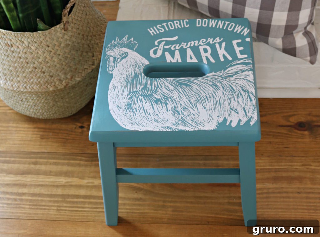 Wooden Step Stool Reimagined 12 A close-up shot of the elegant vintage teal painted wooden step stool with a delicate, intricate stencil pattern on its surface.