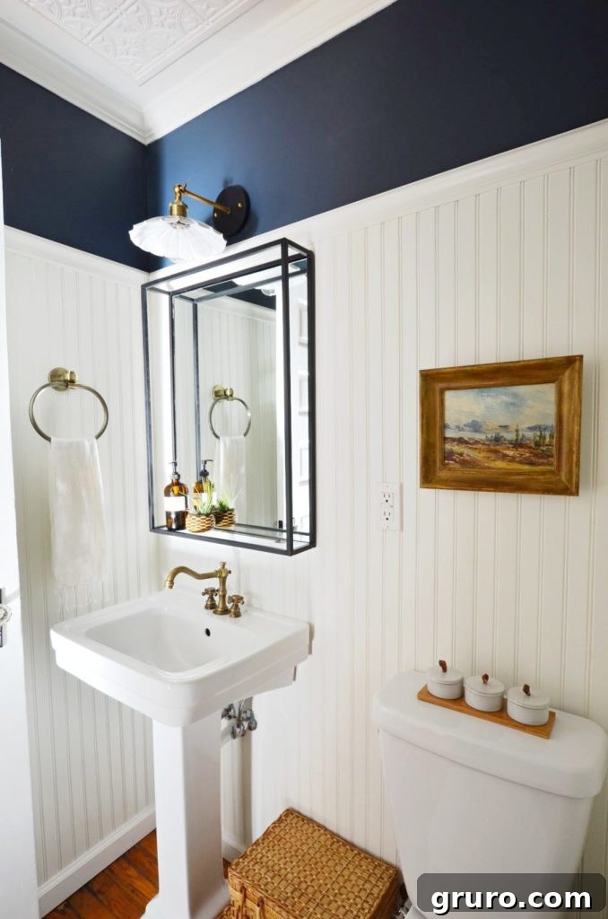 Navy and White Vintage Modern Powder Room with dark navy walls and bright white fixtures